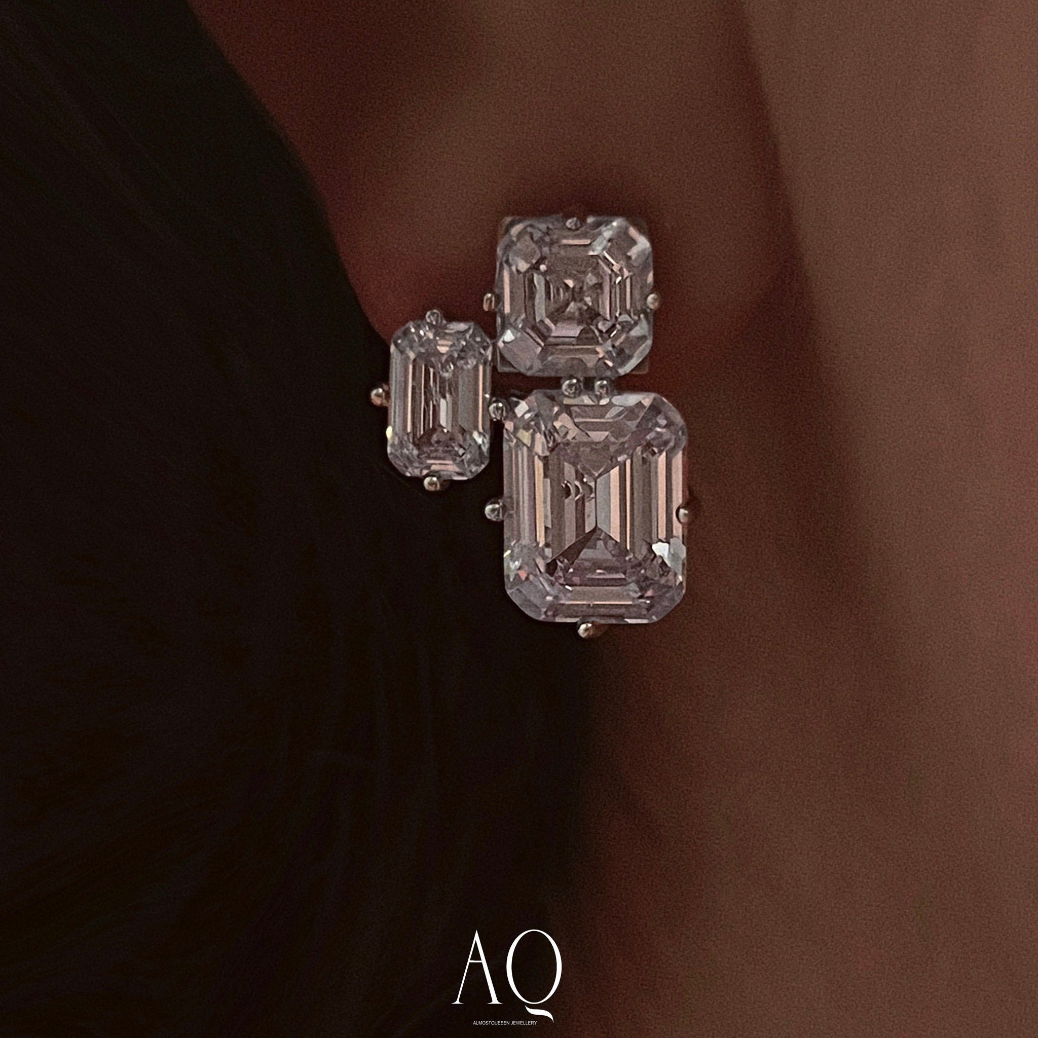 Triple Emerald Cut Studs: Rhodium-plated Sterling Silver Statement Earrings Adorned With High Carbon Diamonds.