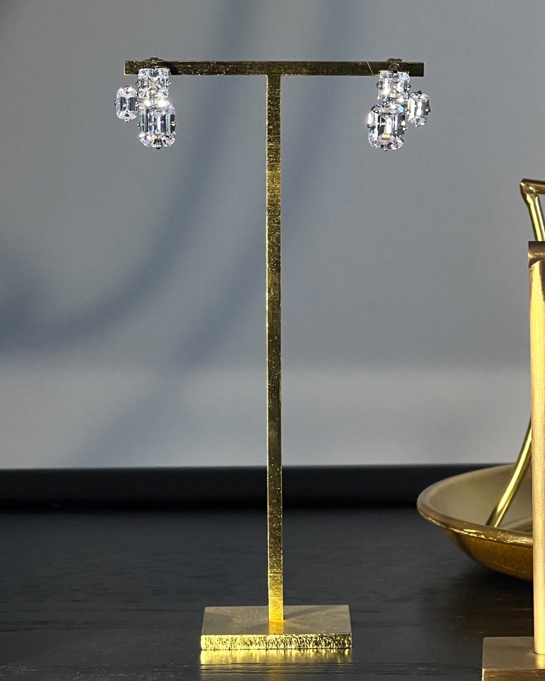 Triple Emerald Cut Studs: Rhodium-plated Sterling Silver Statement Earrings Adorned With High Carbon Diamonds.