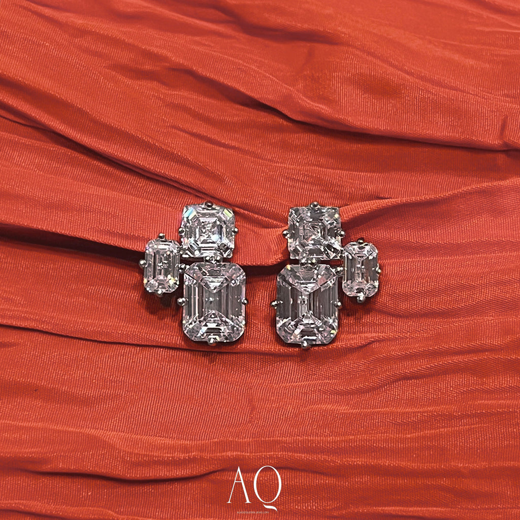 Triple Emerald Cut Studs: Rhodium-plated Sterling Silver Statement Earrings Adorned With High Carbon Diamonds.