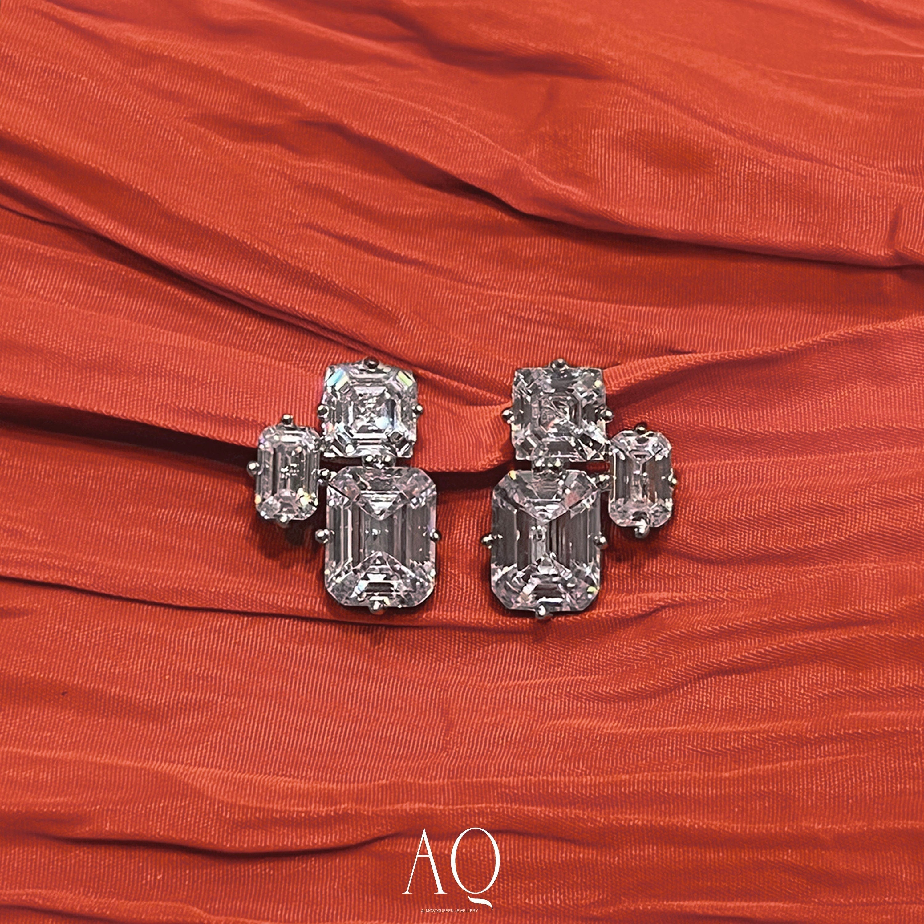 Triple Emerald Cut Studs: Rhodium-plated Sterling Silver Statement Earrings Adorned With High Carbon Diamonds.