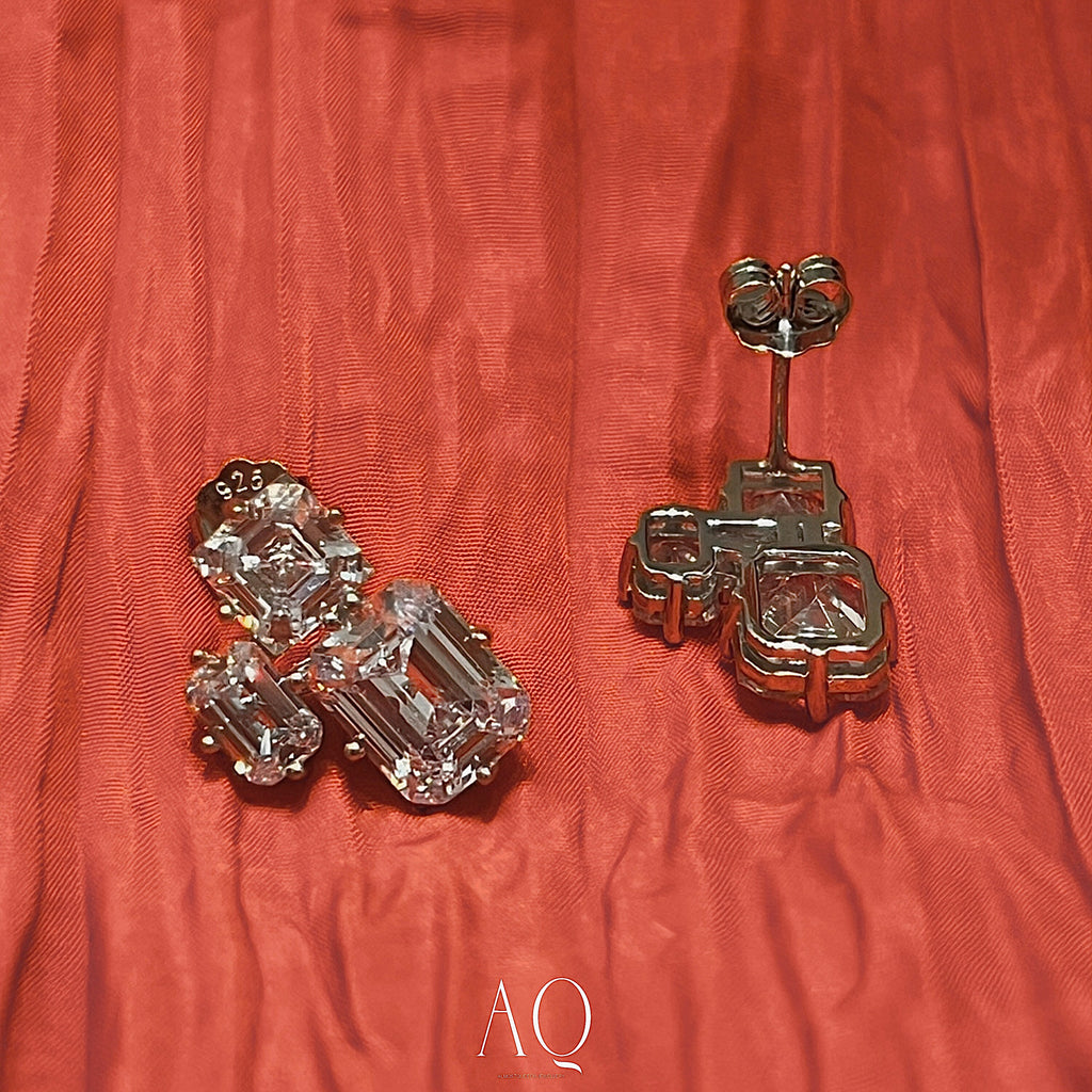 Triple Emerald Cut Studs: Rhodium-plated Sterling Silver Statement Earrings Adorned With High Carbon Diamonds.