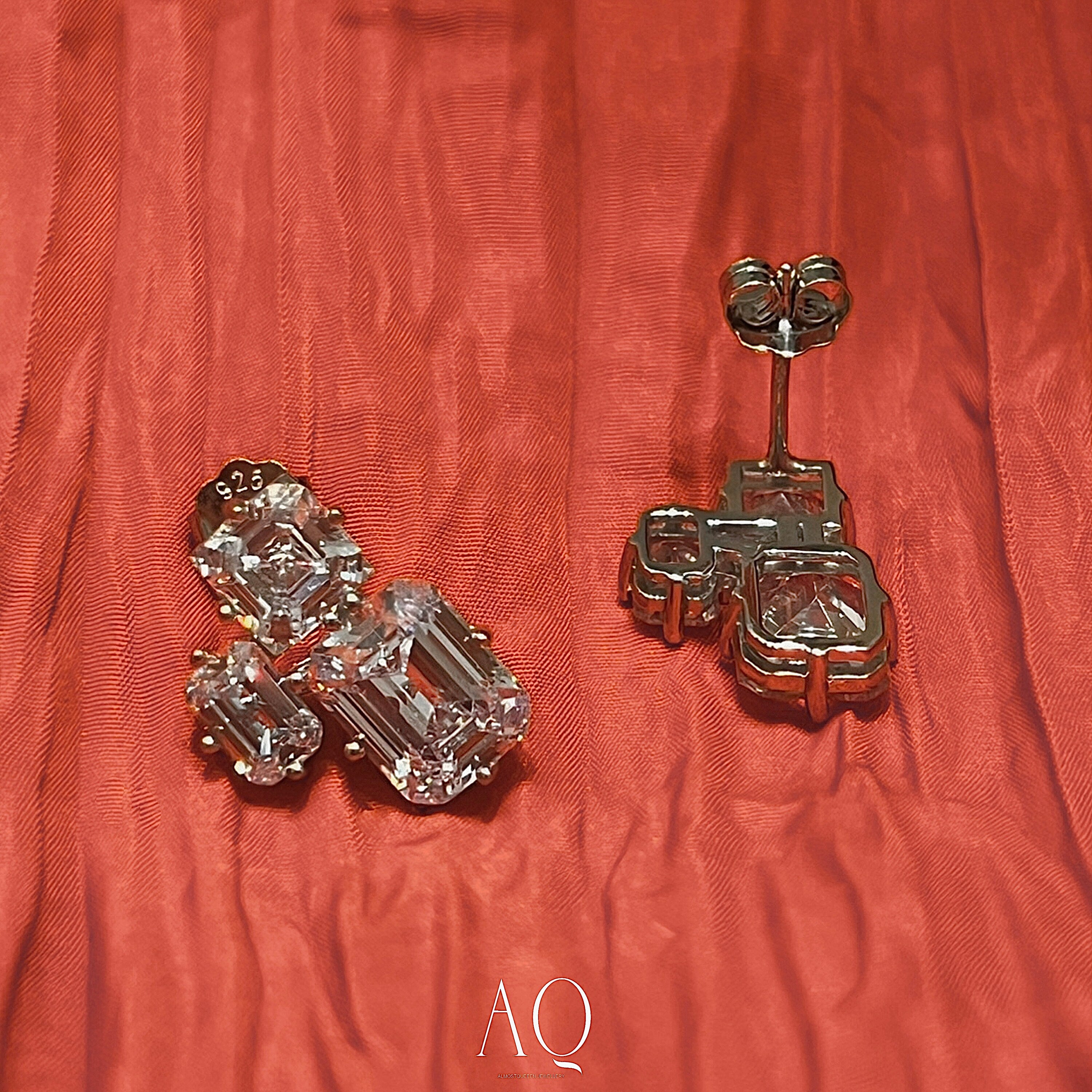 Triple Emerald Cut Studs: Rhodium-plated Sterling Silver Statement Earrings Adorned With High Carbon Diamonds.